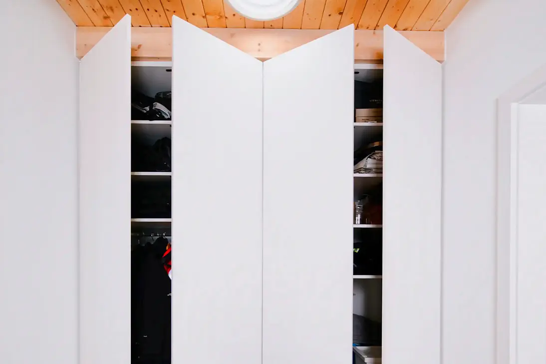Geöffneter weißer Einbauschrank mit Tip-on-Funktion, Stauraum für Kleidung und Regalfächern