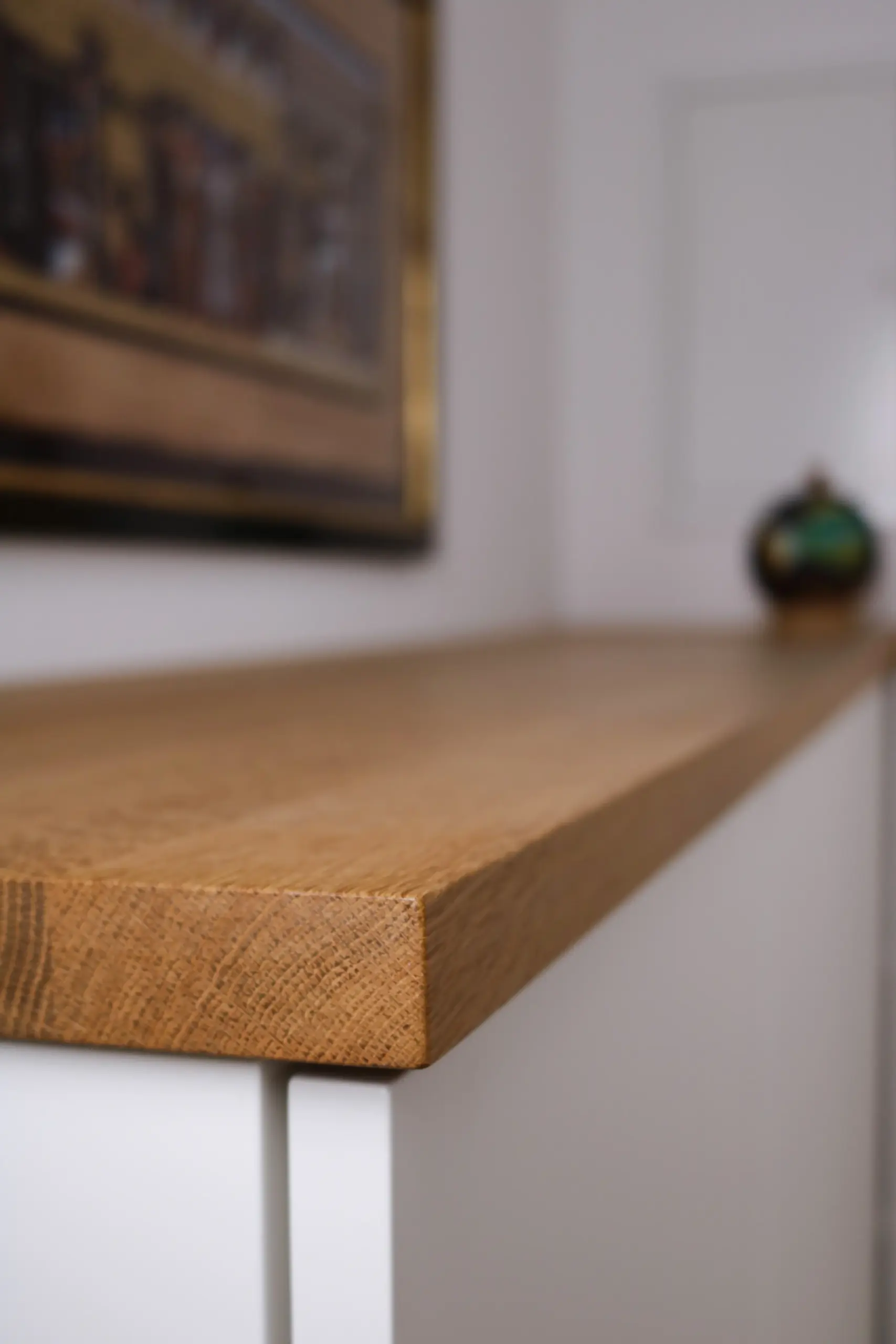 Detailansicht der massiven Eichenholz-Abdeckplatte eines weißen Sideboards mit sichtbarer Holzmaserung
