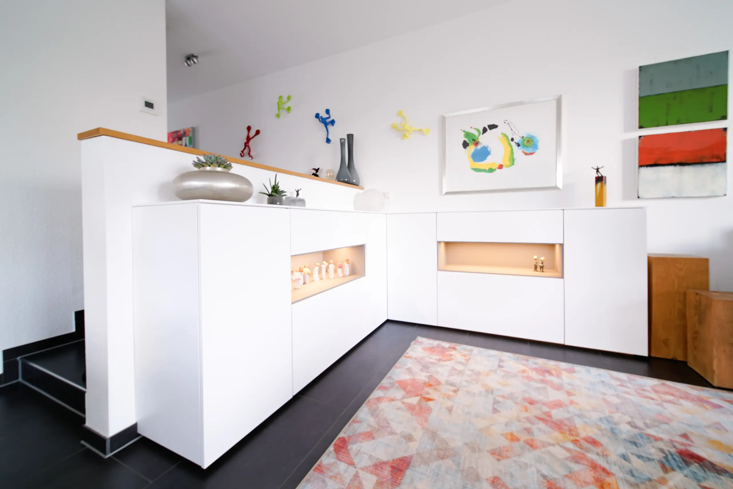 Maßgefertigtes weißes Eck-Sideboard mit beleuchteten Regalfächern und klarer, moderner Gestaltung