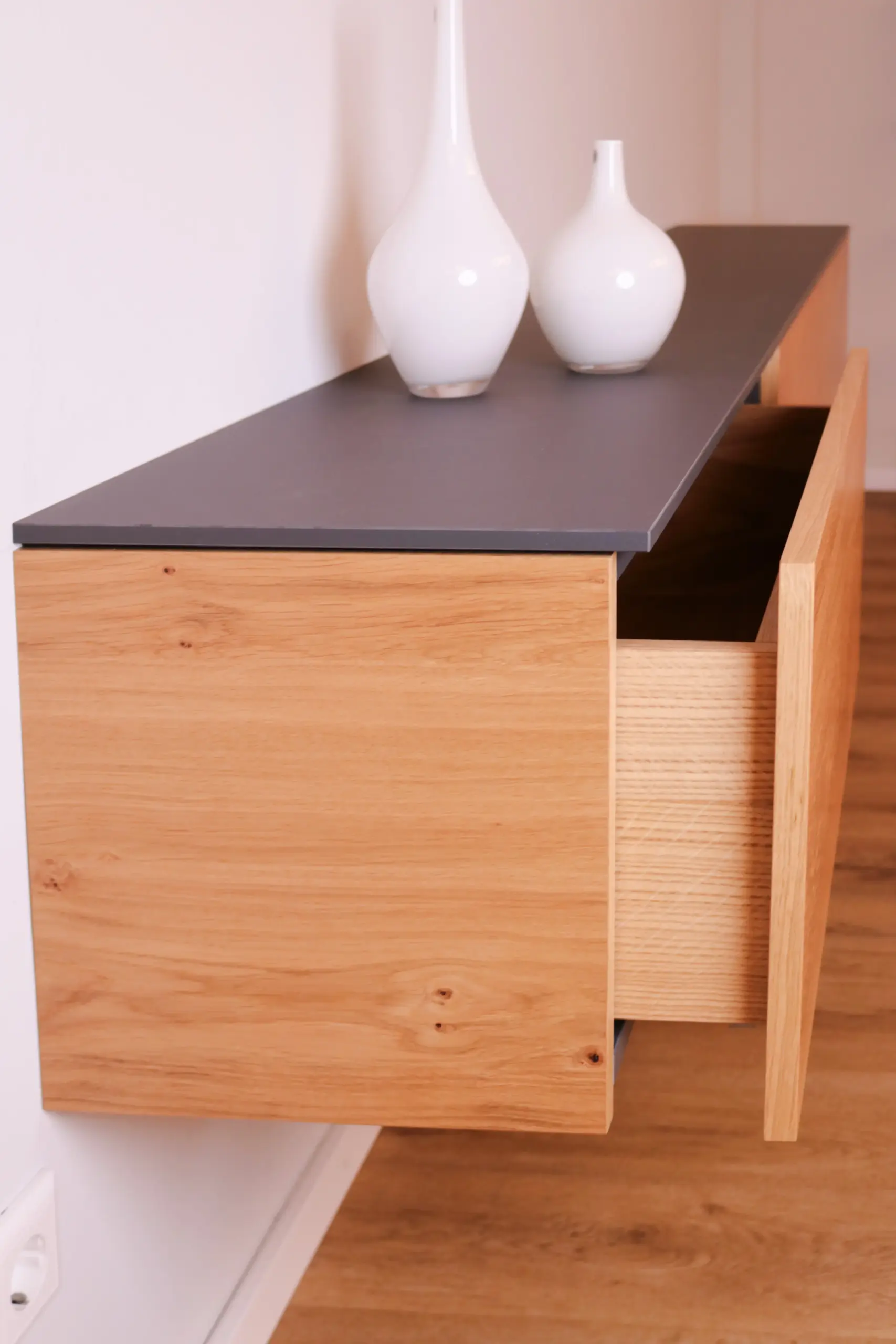 Detailansicht einer geöffneten Schublade des schwebenden Sideboards aus Holz