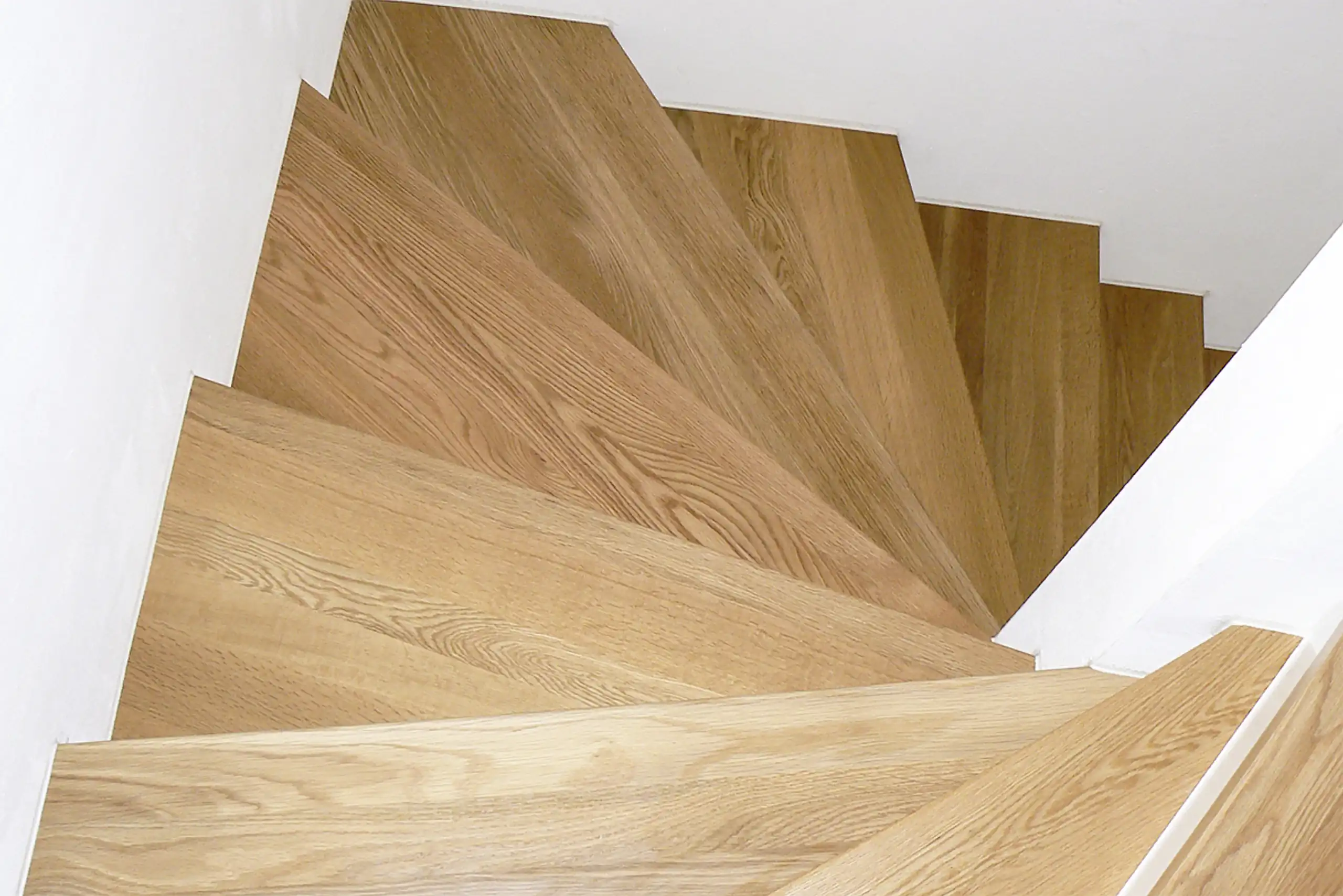 Nachgedacht für ein paar Sekunden Wendeltreppe mit fächerförmigen Eichenholzstufen zwischen weißen Wänden