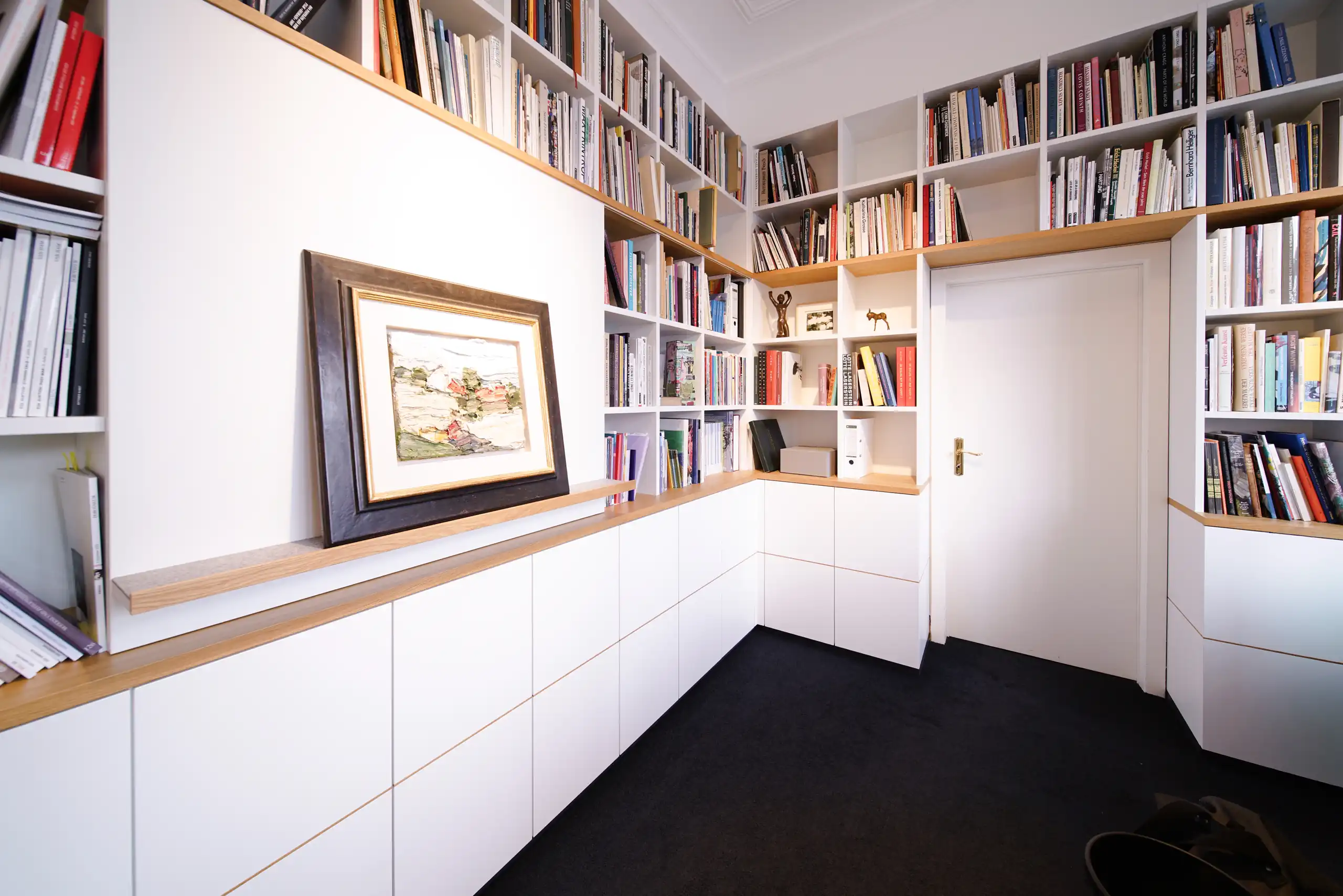 ndividuelle Präsentationswand mit deckenhohen Bücherregalen, Holzdetails und maßgefertigtem Stauraum